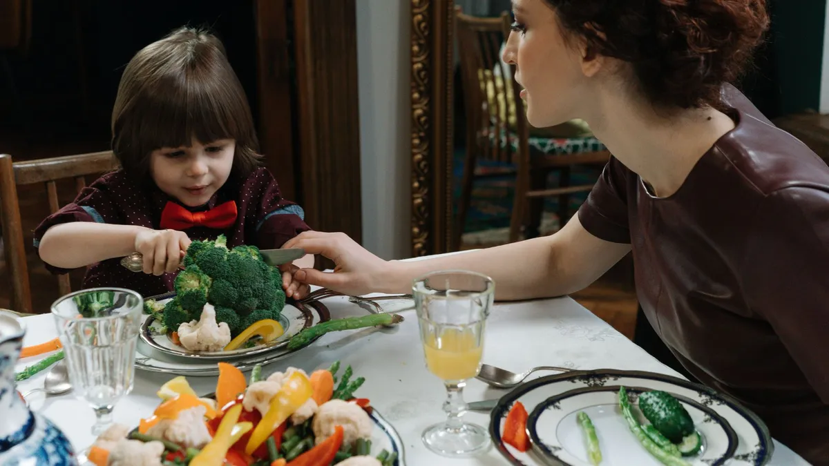 Bébé assis dans une chaise haute qui découvre des morceaux de légumes