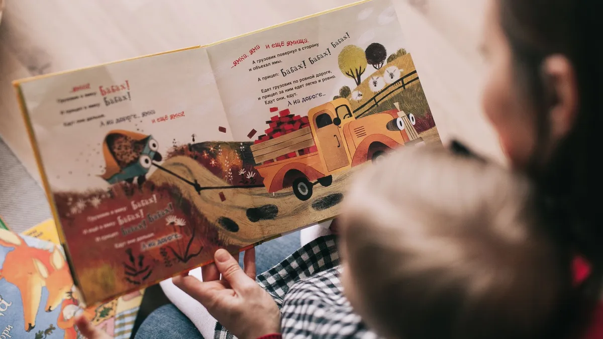 Bébé qui manipule un livre en tissu coloré au sol