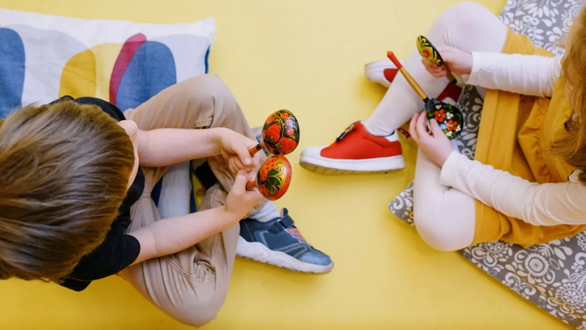 Bébé qui secoue des maracas colorées lors d'une séance d'éveil musical