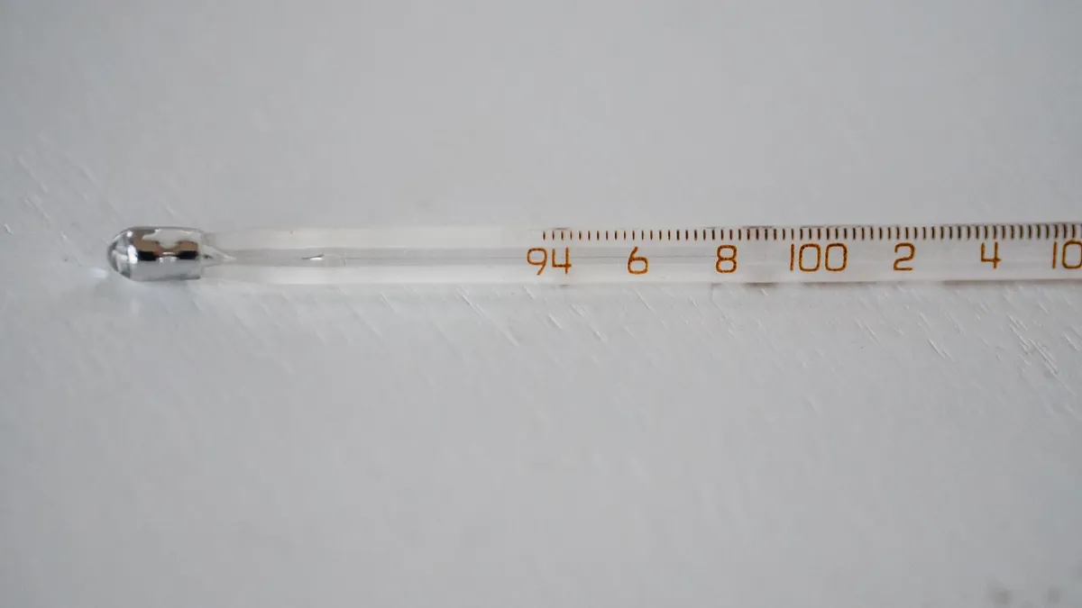 Maman prenant la température de son bébé avec un thermomètre