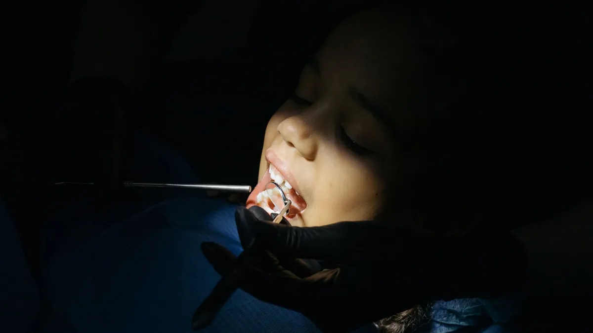 Enfant chez le dentiste lors d'un contrôle, illustration des garanties d'une mutuelle enfant