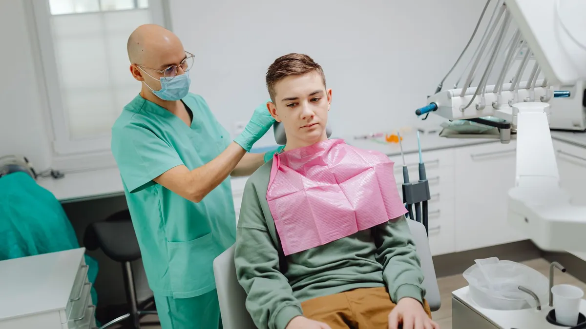 Adolescent souriant portant un appareil dentaire chez l'orthodontiste