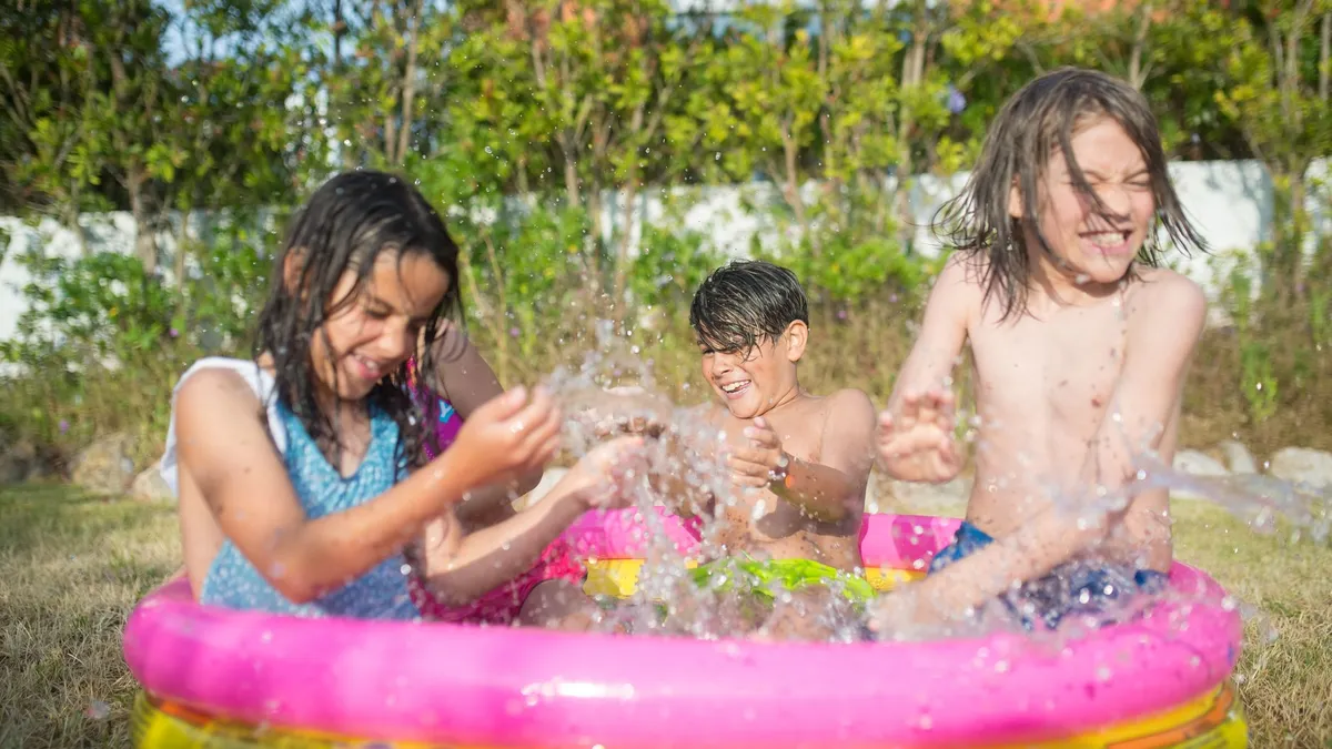 Piscine gonflable pour enfants dans un jardin, eau claire un jour de canicule
