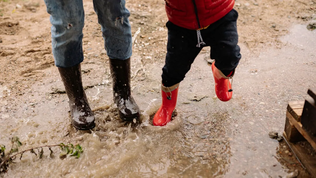 Enfants qui sautent dans les flaques en bottes de pluie, occupés sans écran