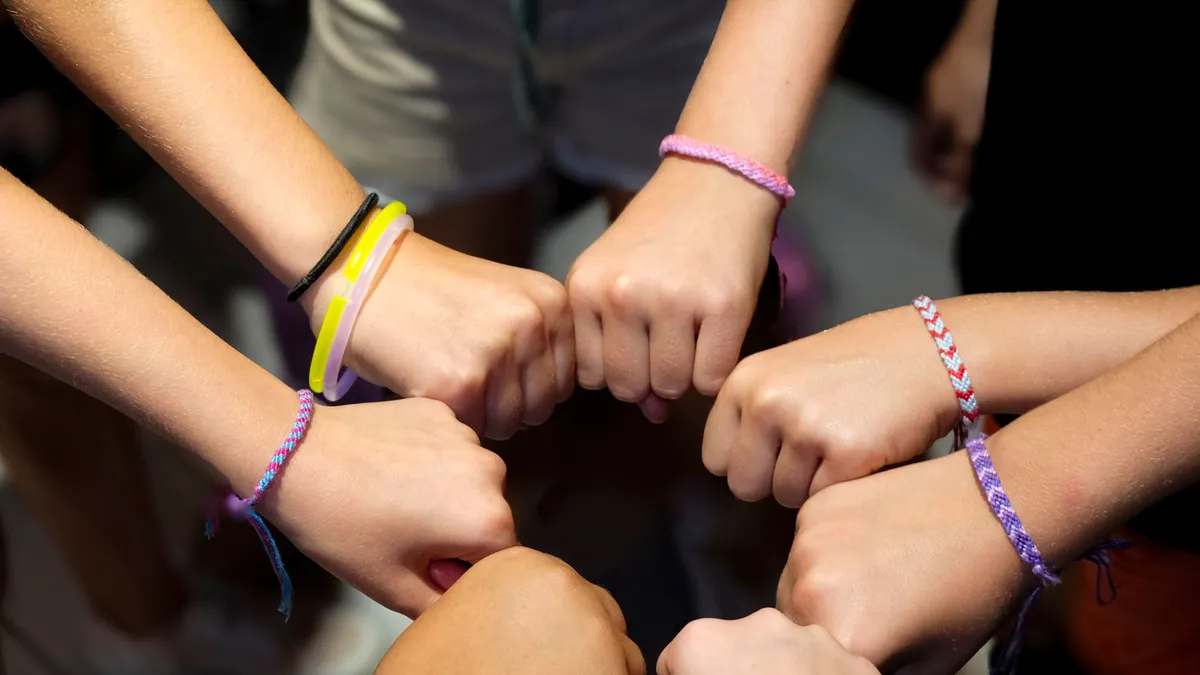 Mains de parents et d'enfants réunies symbolisant la transmission familiale